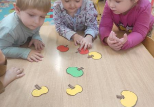 Dzieci segregują jabłka wg. koloru.